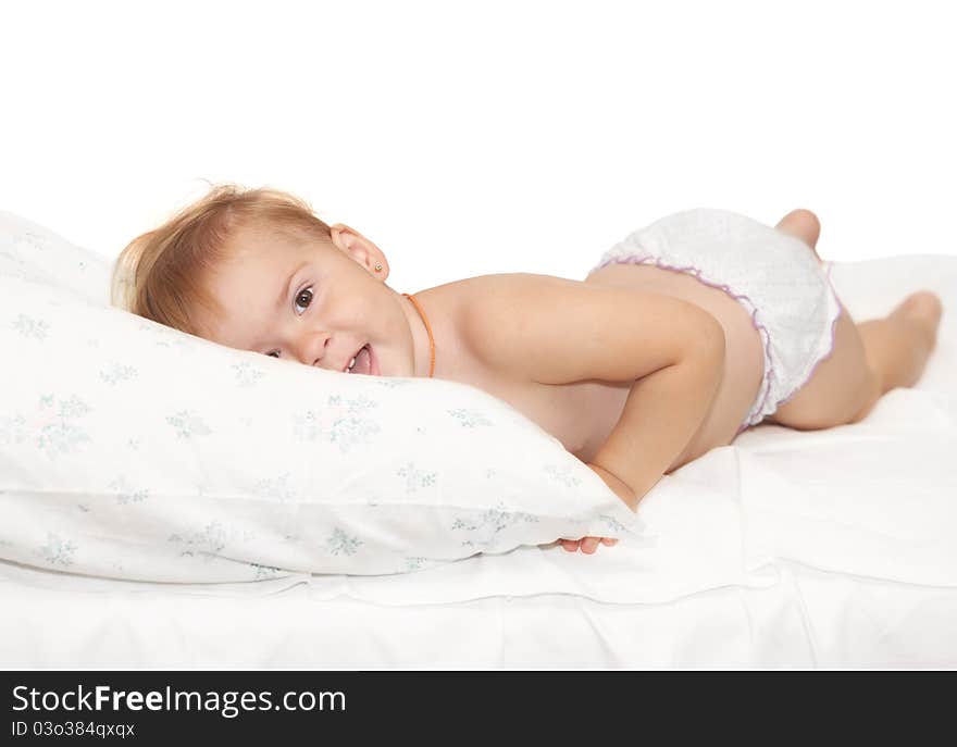 Beautiful baby lays on a white pillow. Beautiful baby lays on a white pillow