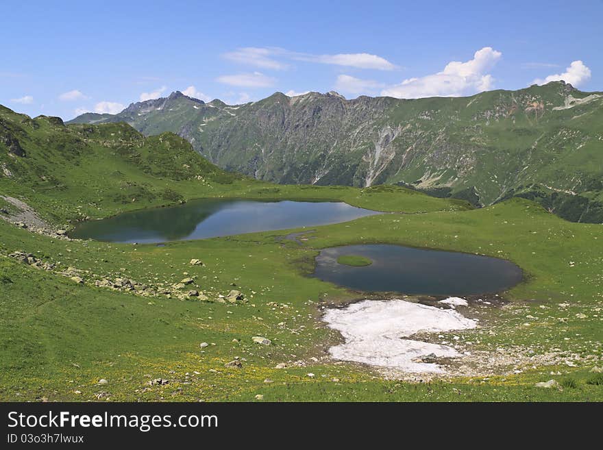 Snow lying at mountain lake in summer season