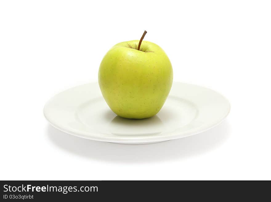 Green apple on the white plate