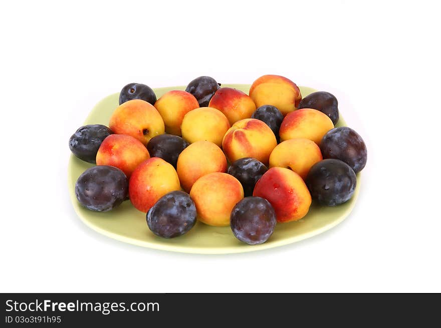 Still life with natural ripe plums and peaches on a white background