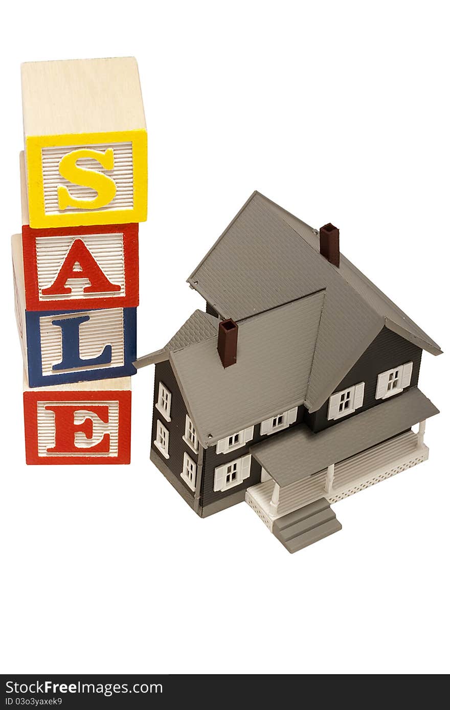 House model next to blocks spelling out the word sale. House model next to blocks spelling out the word sale.