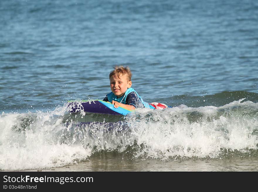 A young boy learning to boggie board. A young boy learning to boggie board