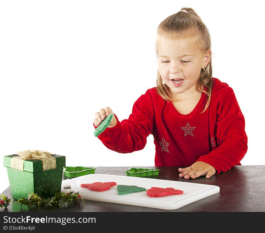 A cute preschooler happily making Christmas cookies from colorful kiddie dough. A cute preschooler happily making Christmas cookies from colorful kiddie dough.