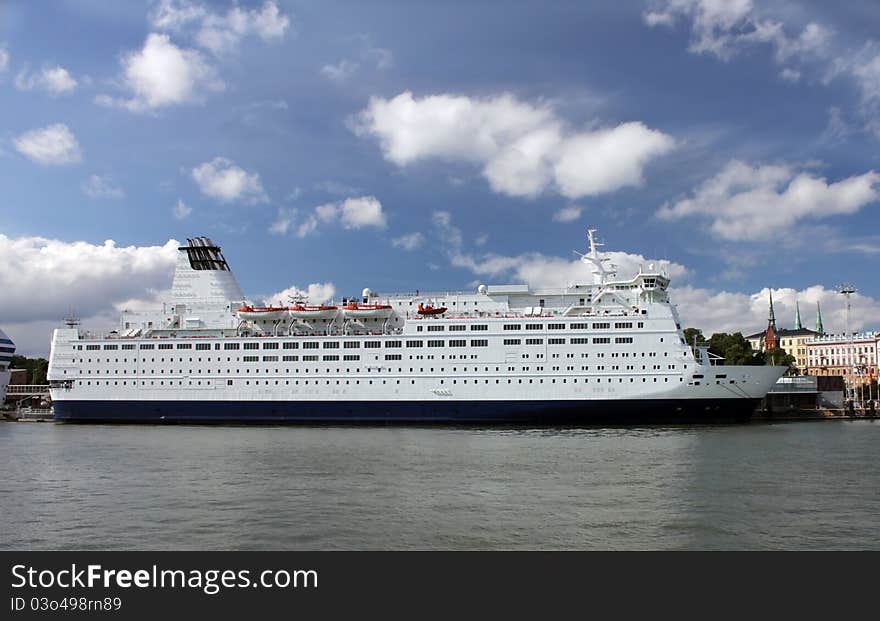 Passenger ship in port. The calm wave and cloudy sky.