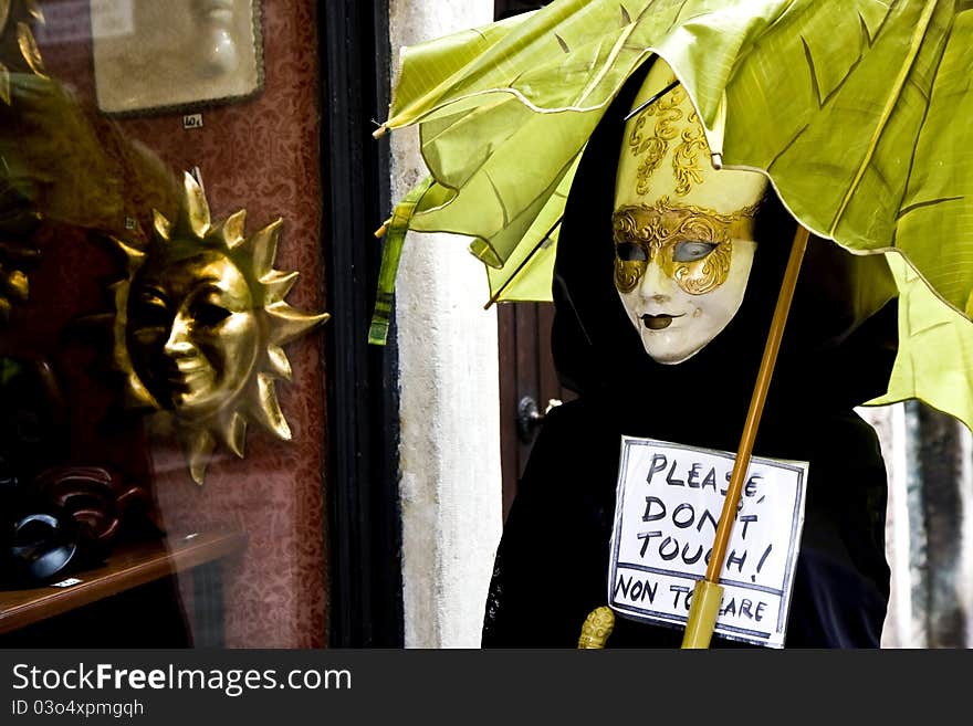 Doll in Venetian costume in front of a store