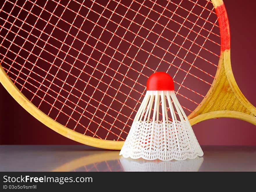 Shuttlecock and racket badminton on a red background