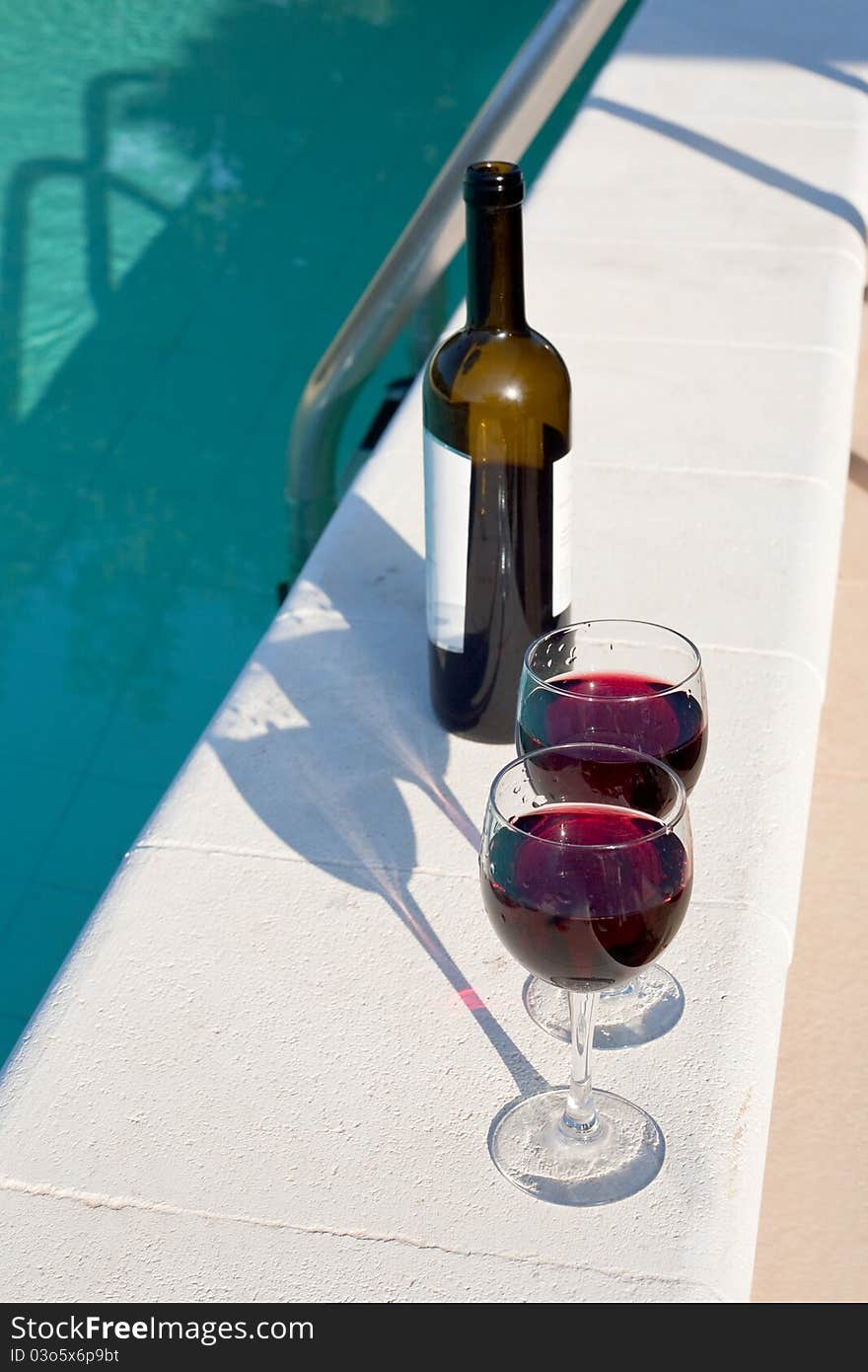 Bottle and two glasses with red wine outdoor