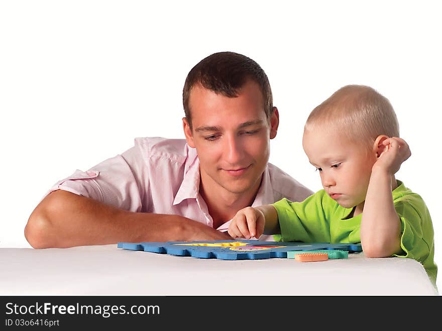 Smart dad and his son play at table. Smart dad and his son play at table