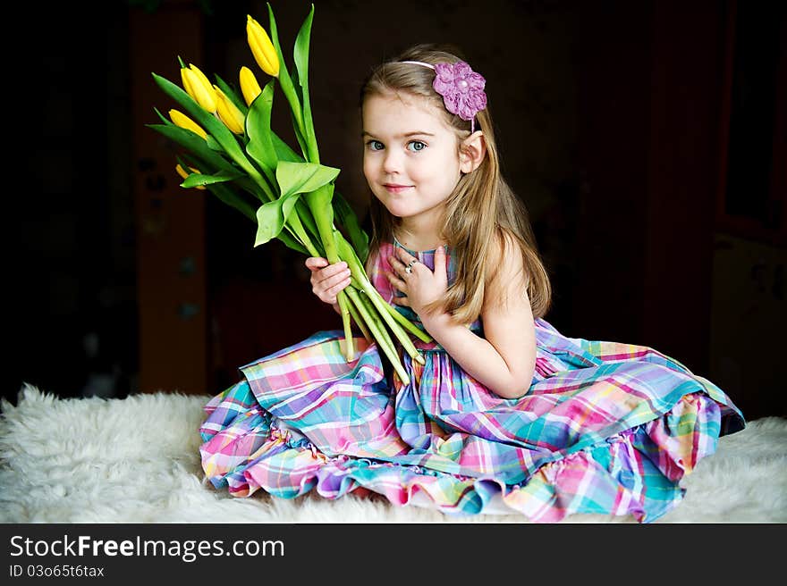 Portrait of a sunny child girl with tulips on a dark background. Portrait of a sunny child girl with tulips on a dark background