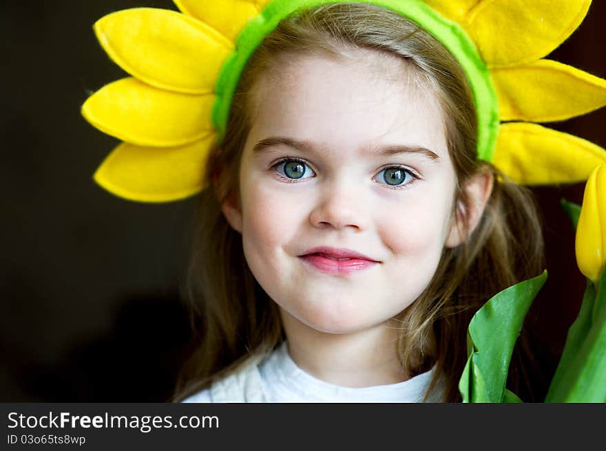 Sunny child girl with yellow crown on dark background. Sunny child girl with yellow crown on dark background