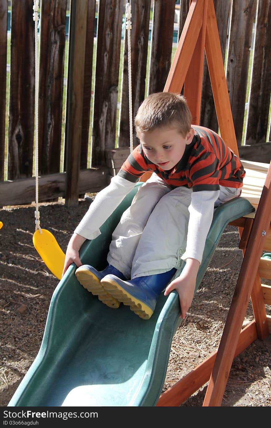 Young blond boy playing on the garden playset. Young blond boy playing on the garden playset