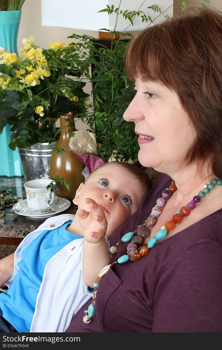 Beautiful baby boy sitting by his grandmother. Beautiful baby boy sitting by his grandmother