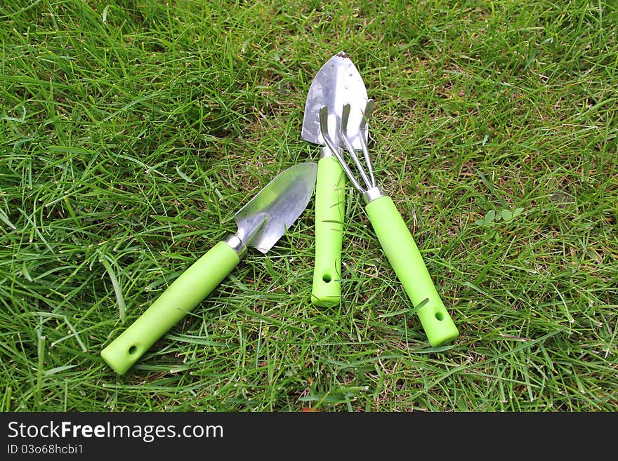 Three child sized garden tools on grass. Three child sized garden tools on grass