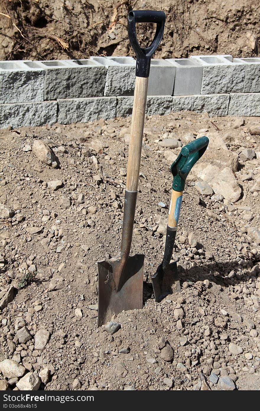 An adult and child sized spade next to one another. An adult and child sized spade next to one another