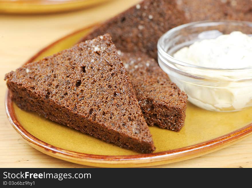 Black bread toasts with garlic sauce on a plate