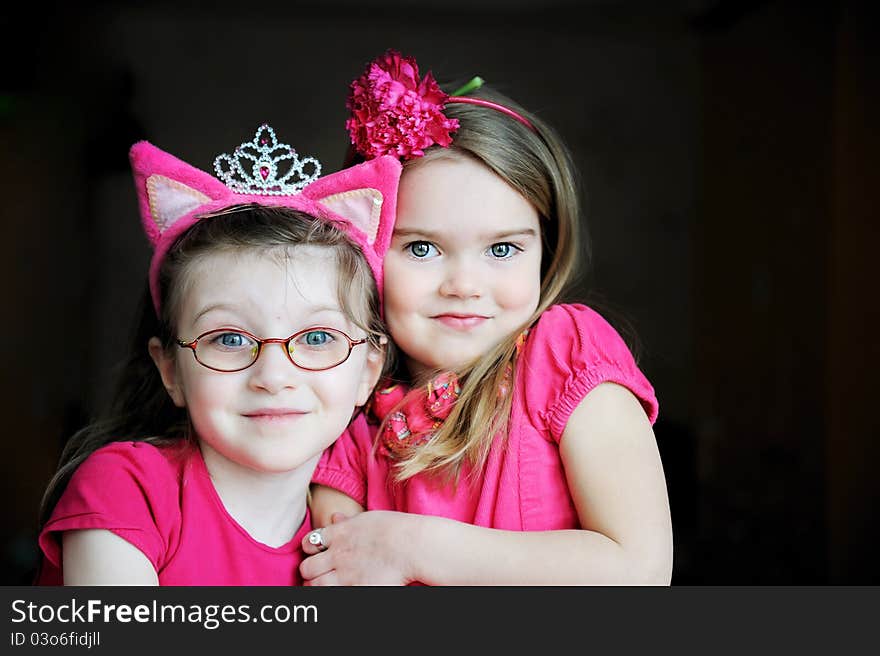 Portrait of two pinky child girls on black background