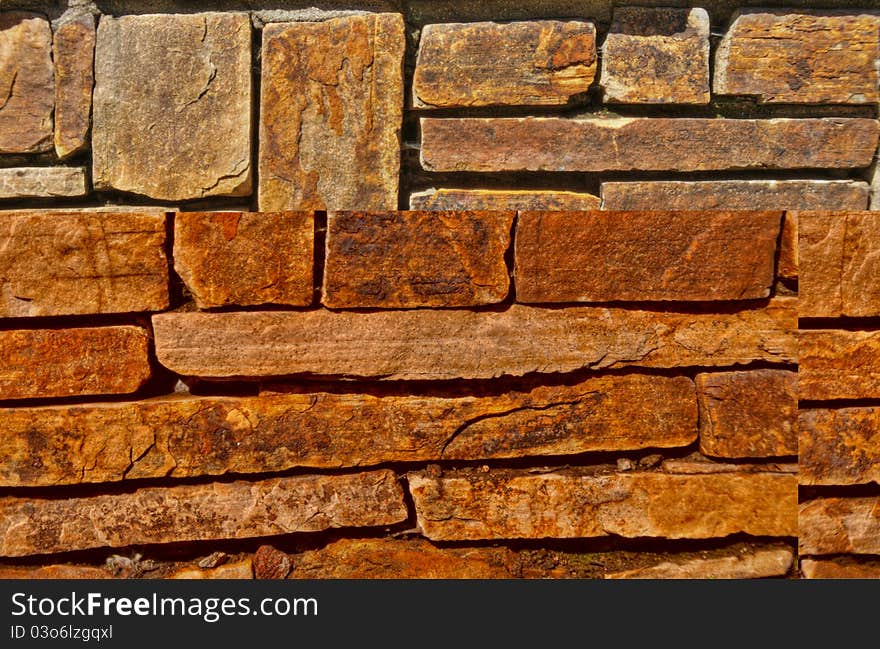 This is part of a stone brick wall with the sun shining on it. This is part of a stone brick wall with the sun shining on it.