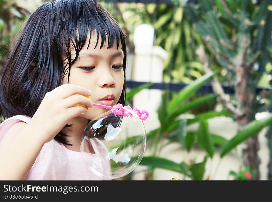 A pink dress girl blowing soap bubbles. A pink dress girl blowing soap bubbles