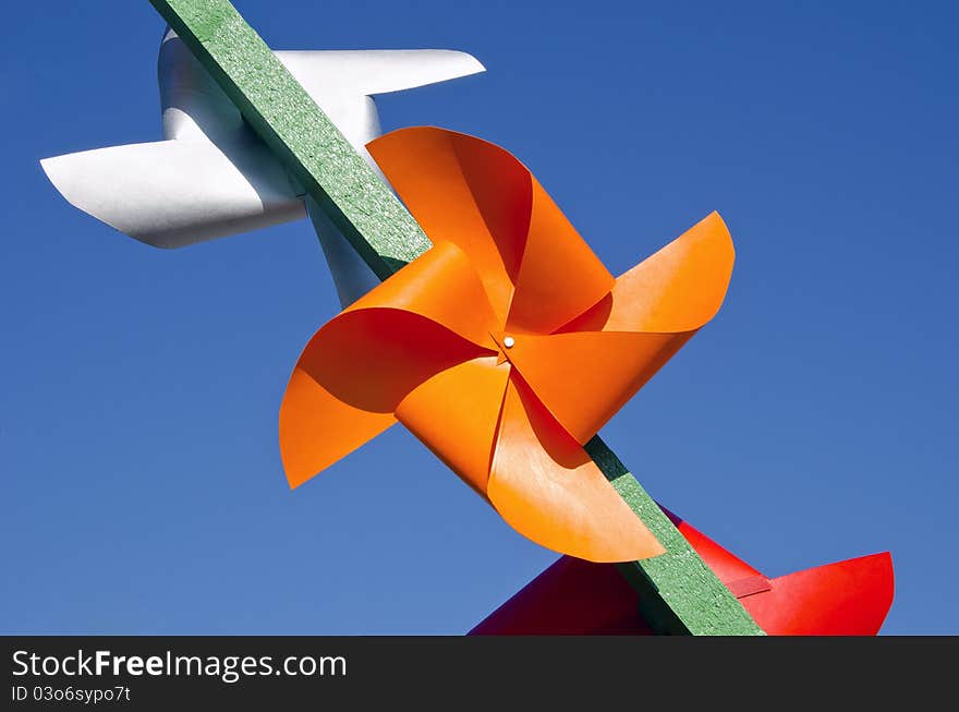 Colourful paper windmills on sky background