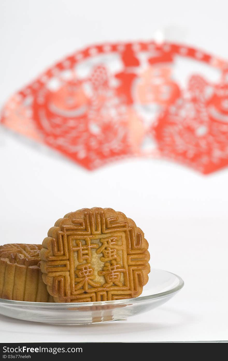 Chinese moon cakes on a plate with Chinese paper cutting background