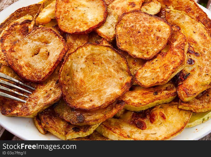 Fried zucchini with garlic closeup on a plate