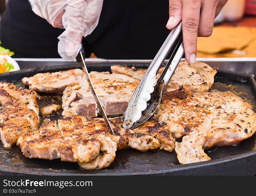 Grilled steaks are cut while cooking on the stove