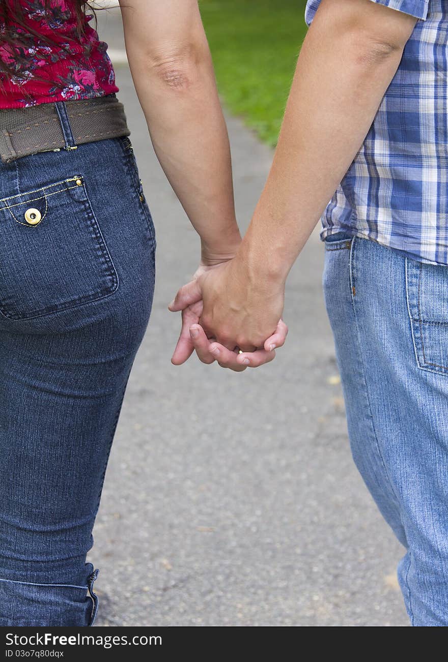 Couple walking in the park hand in hand.