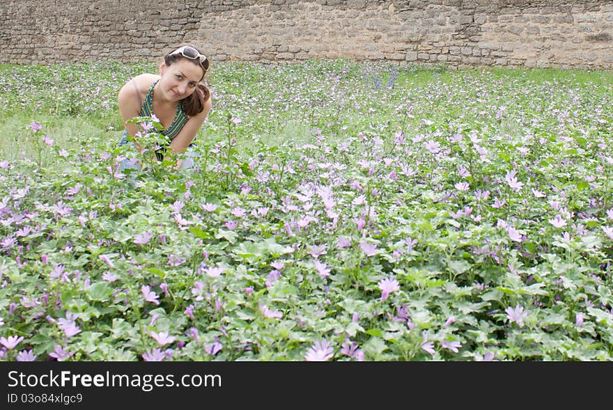 A girl sits in the wild flowers in the street shooting