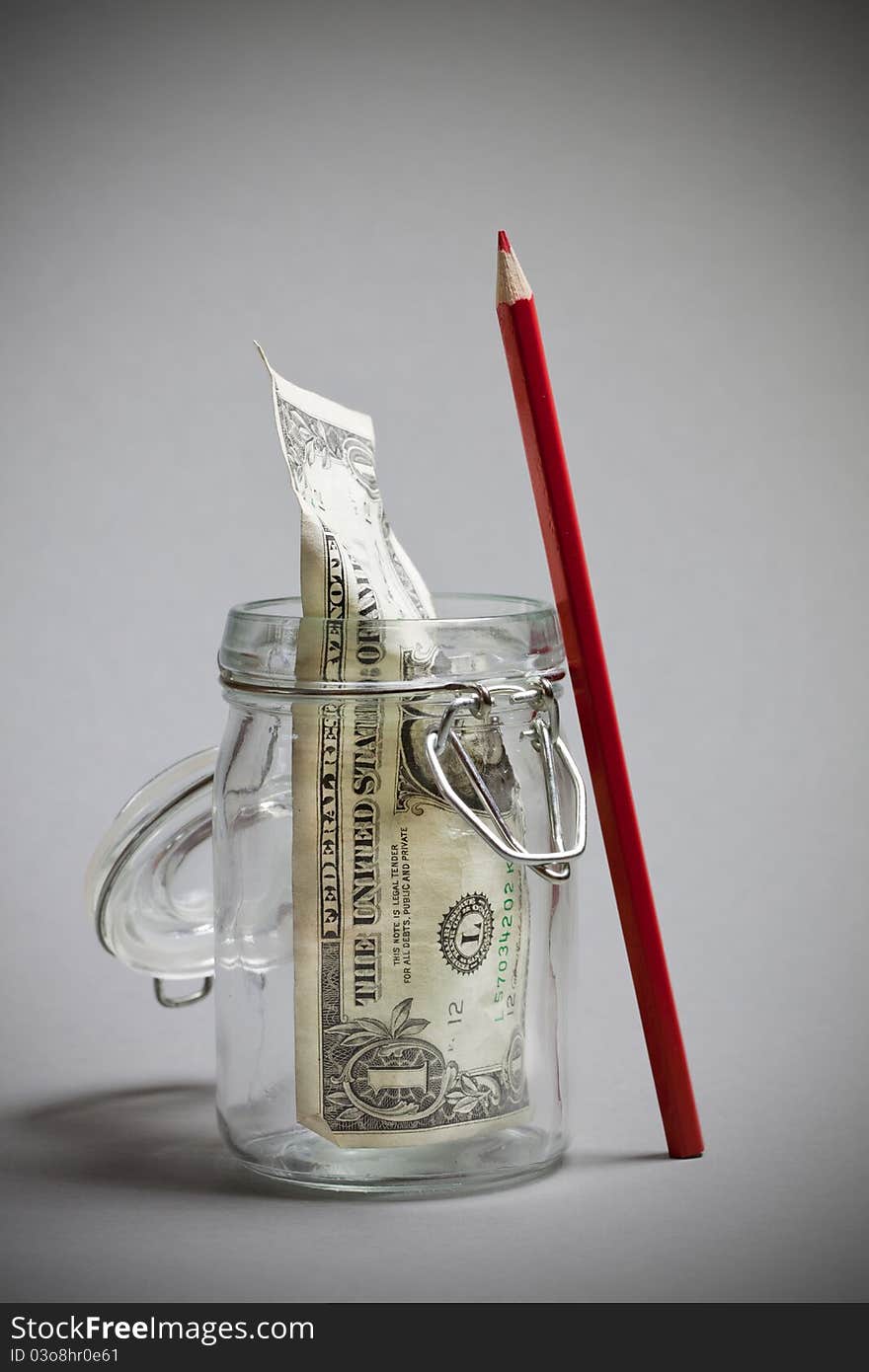 Dollar note in a jar with red pencil concept. Dollar note in a jar with red pencil concept