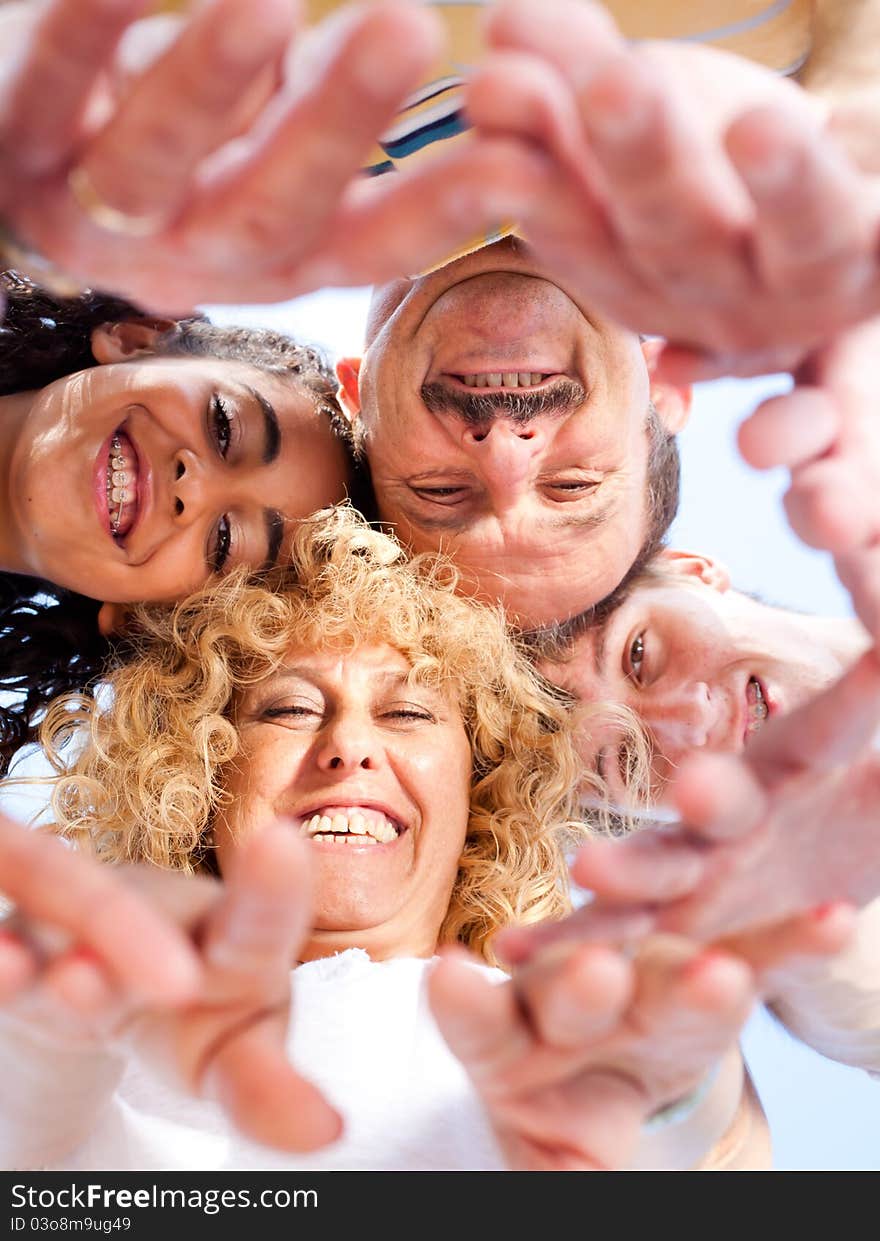 Below view of family members head by head smiling at camera.