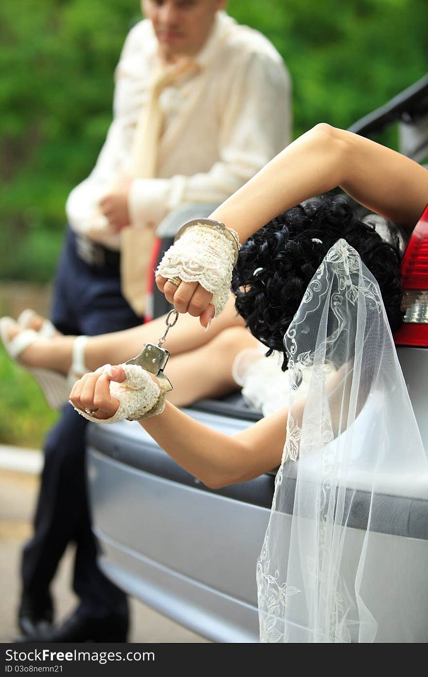 Groom discharging of captive bride from car trunk. Groom discharging of captive bride from car trunk