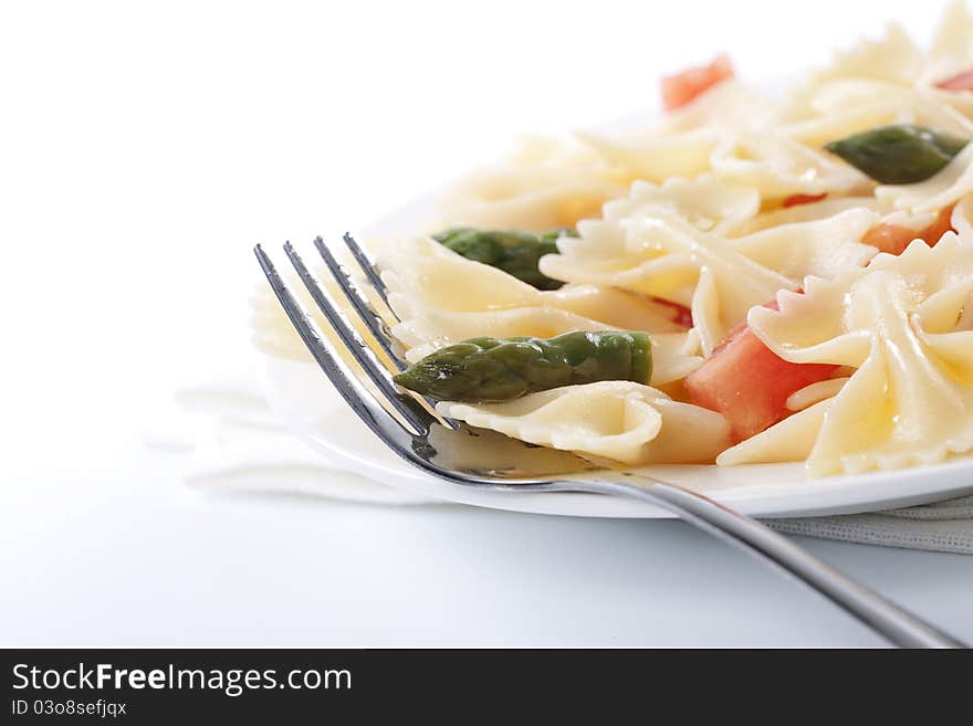 Pasta farfalle, tomato and asparagus salad on white background