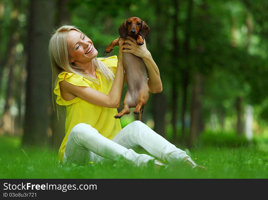 Woman dachshund in her arms on grass