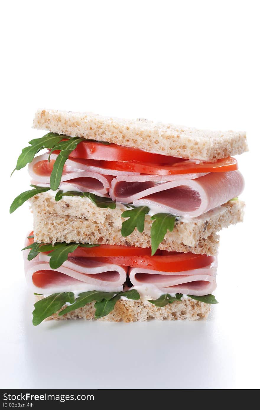 Sandwich with ham,tomato, and rucola salad on white