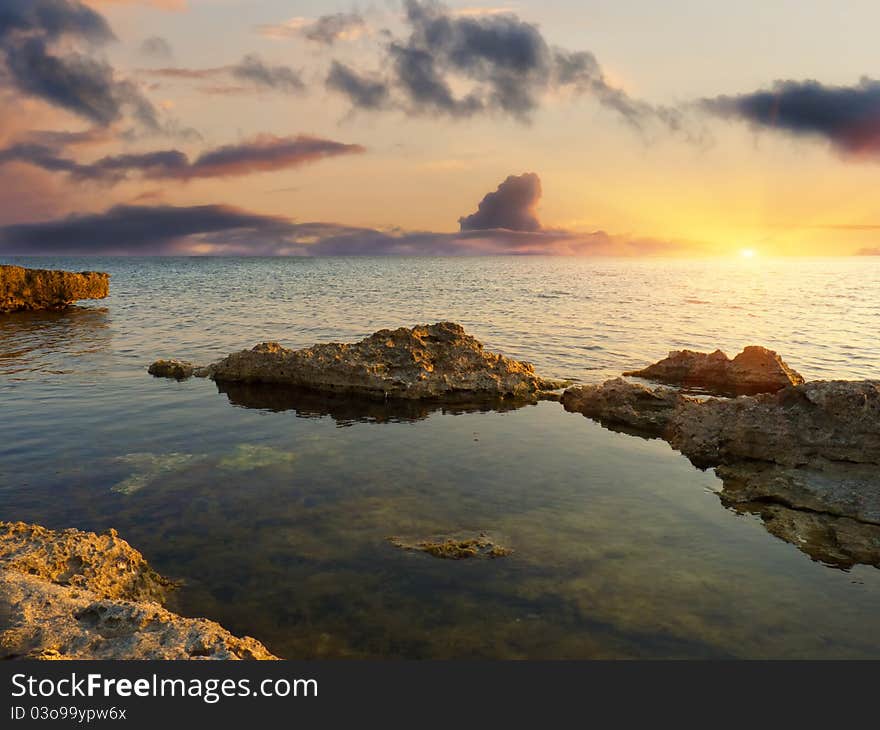 Sea and rock at the sunset. Nature composition.