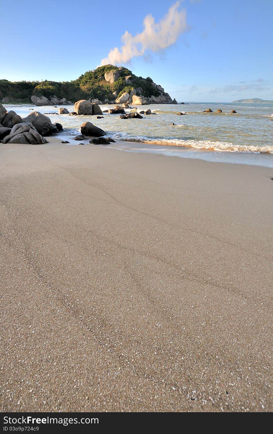 Beach sand on sea coast with rock under sunrise lighting, hown as sea coast physiognomy and landscape. Beach sand on sea coast with rock under sunrise lighting, hown as sea coast physiognomy and landscape.