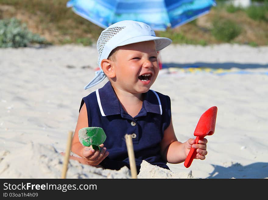 The kid at the beach playing with sand