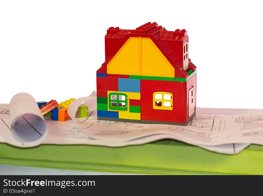 Toy house near drawings and blocks