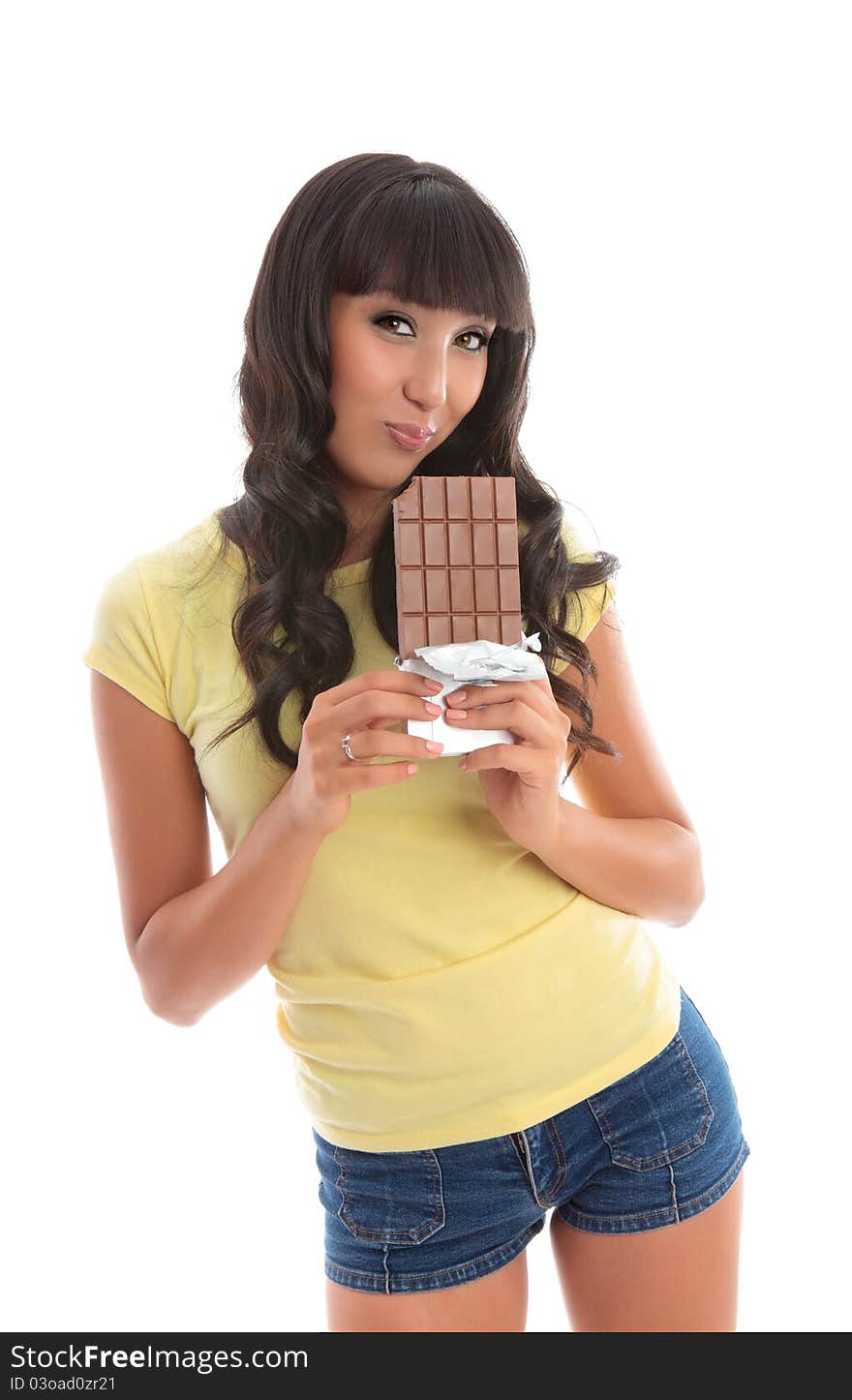 A beautful girl eating from a lblock of decadent chocolate. White background. A beautful girl eating from a lblock of decadent chocolate. White background