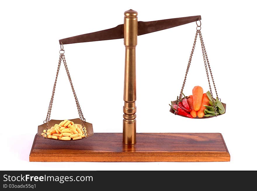 Tablets and fresh vegetables on a brass scale. Tablets and fresh vegetables on a brass scale