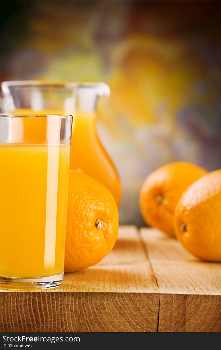 Studio shot 
glass with juice and oranges on wooden boards