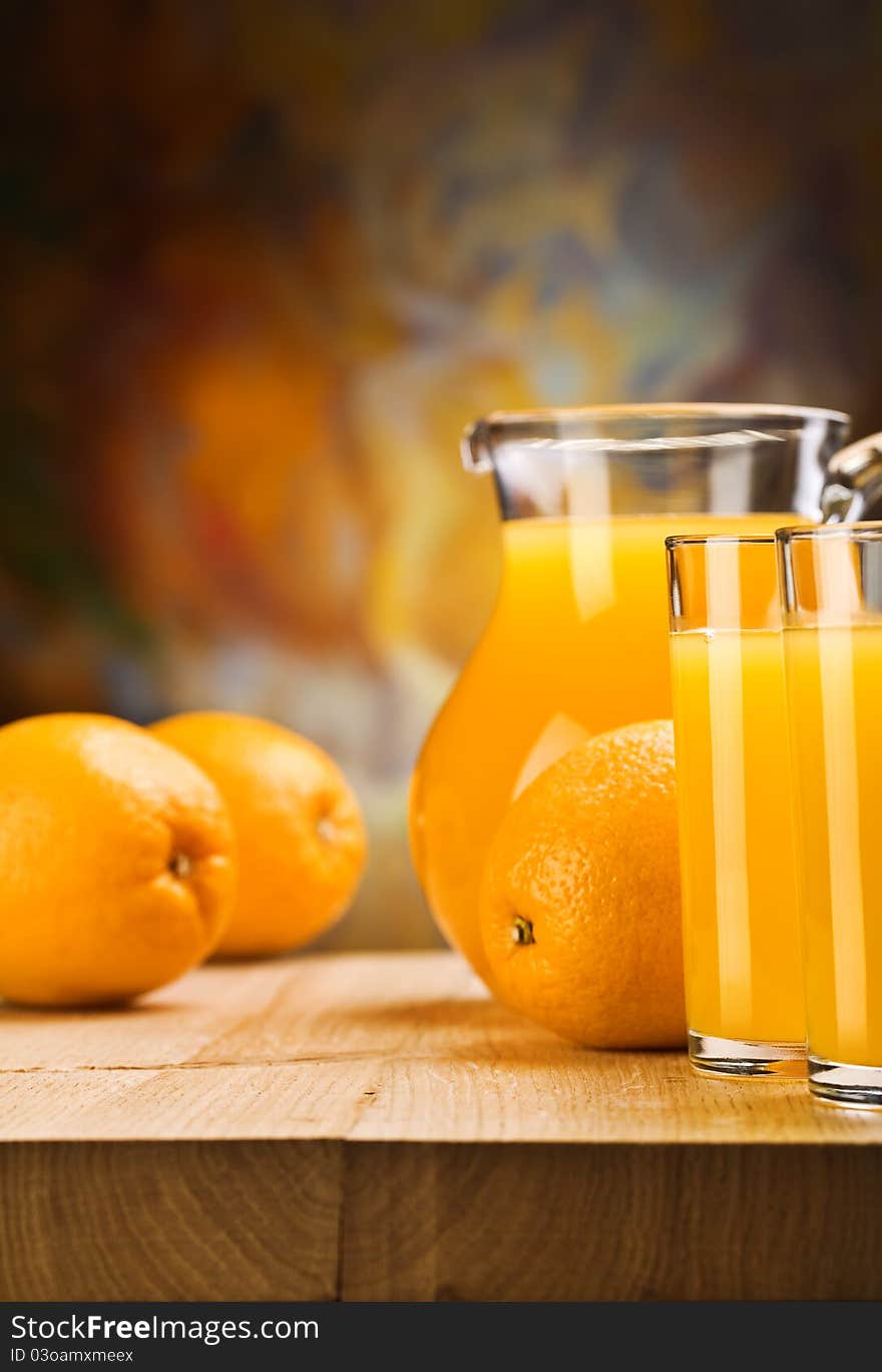 Oranges and juice of oranges on glass and jug on wooden boards