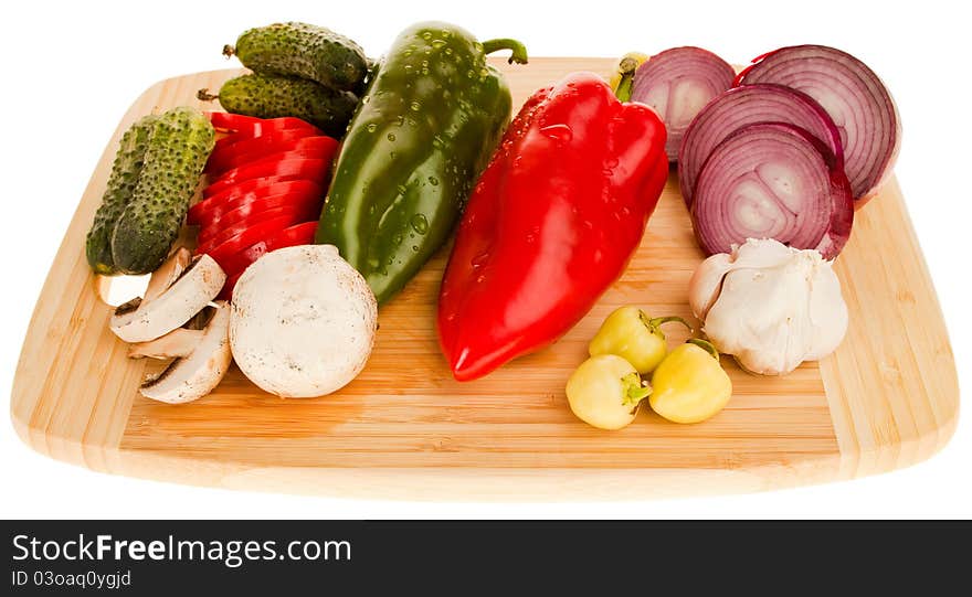 Various fresh vegetables on wooden cutting board, isolated on white. Various fresh vegetables on wooden cutting board, isolated on white