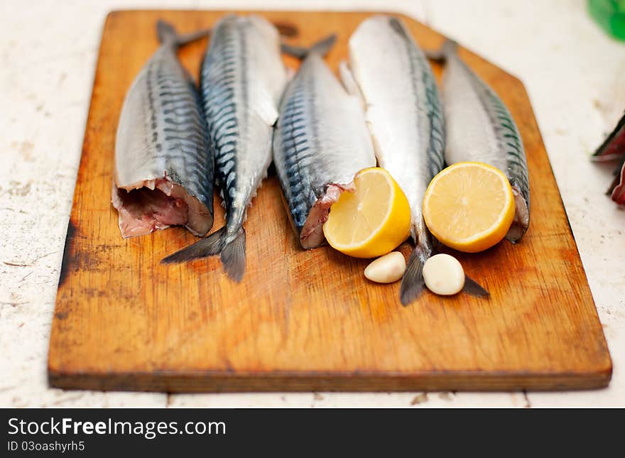 Fish carcass with spices on wooden hardboard, prepared for cooking