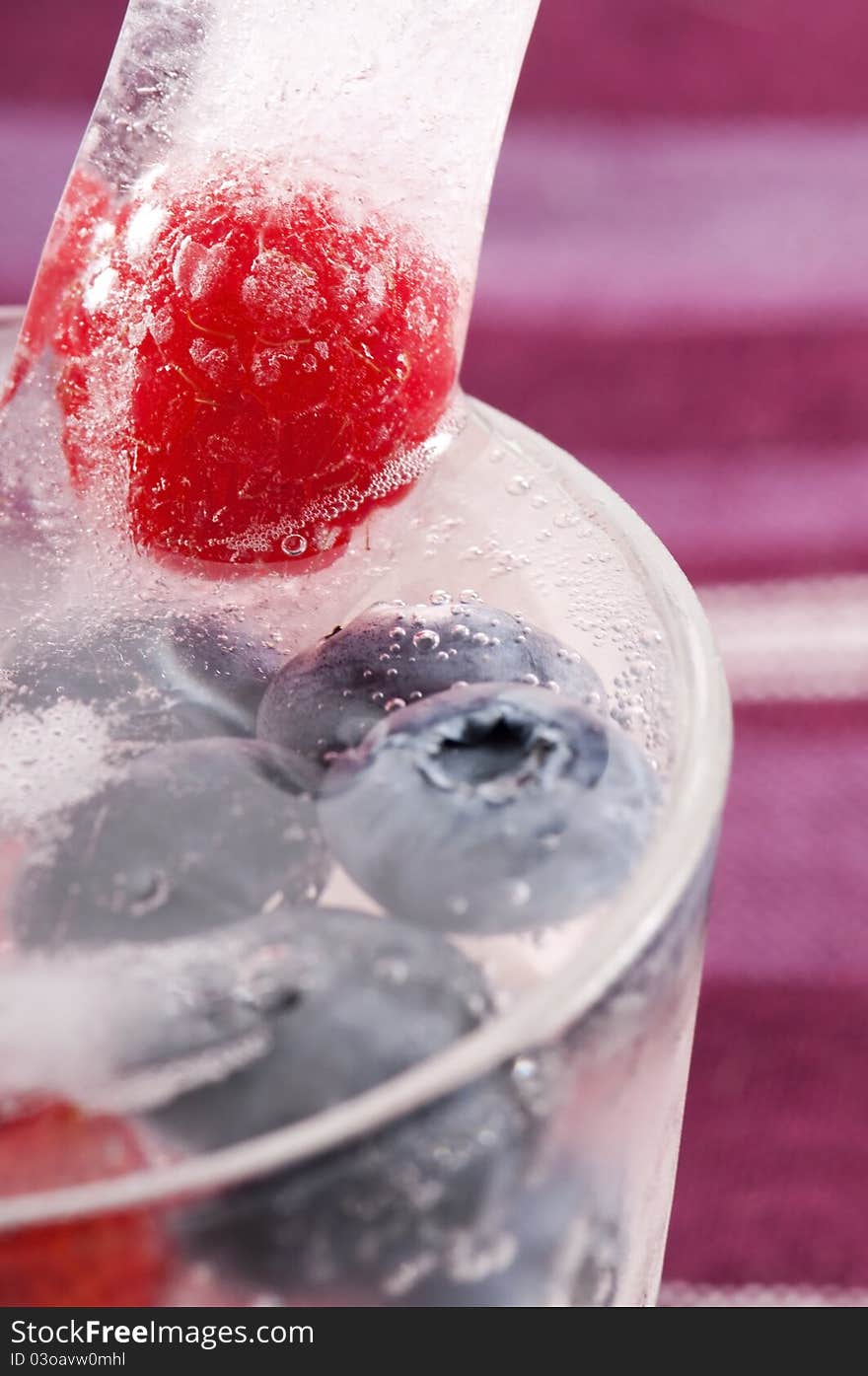 Raspberry and blackberry frozen in ice