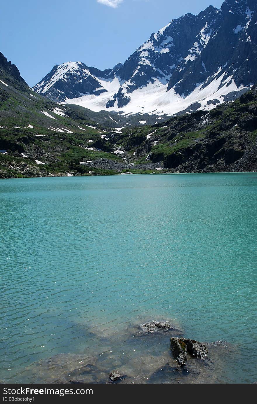 Turquoise alpine lake on the mountain background. Turquoise alpine lake on the mountain background