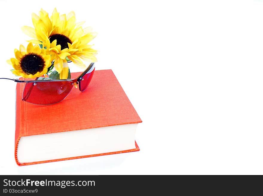 Book and sunglases with a sunflower