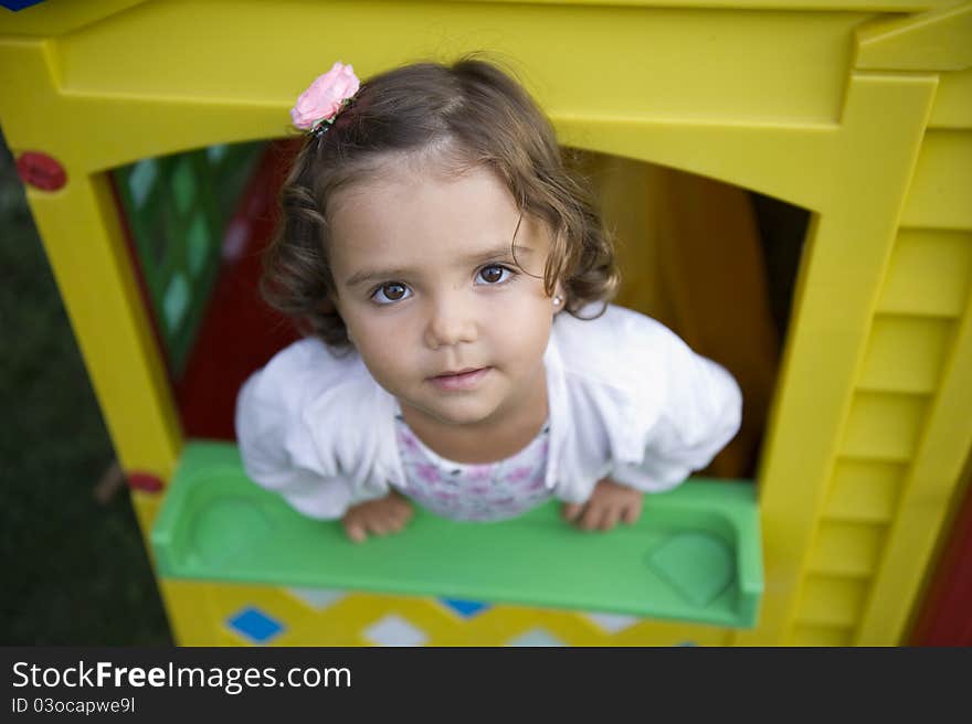 Beautiful little girl playing inside a toy house. Beautiful little girl playing inside a toy house