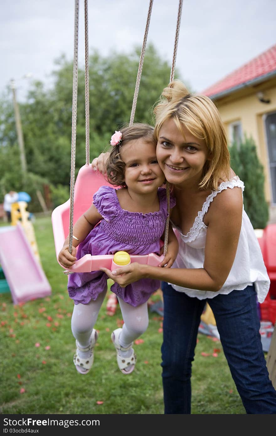 Mom Pushing Daughter on Swing. Mom Pushing Daughter on Swing