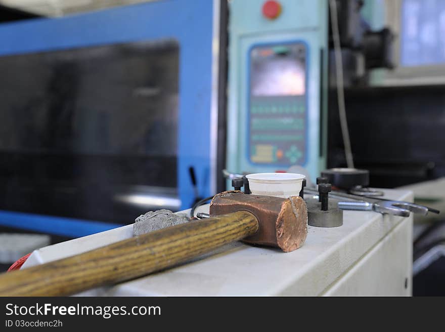 Working tools with a hammer and pliers and kitchen utensils in the background leaning on shelves. Working tools with a hammer and pliers and kitchen utensils in the background leaning on shelves